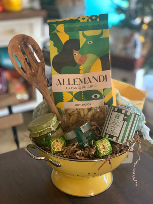 Yellow colander with pasta, jars, and a box labeled 'Allemandi' on a table.